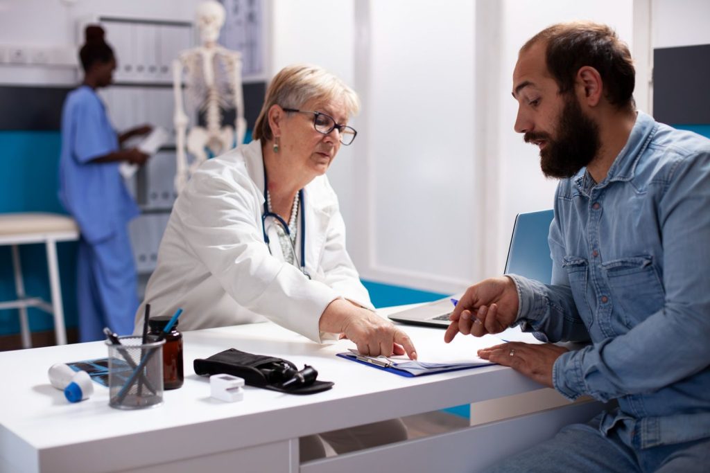 Same day STI test Houston: Doctor in white coat discussing results with patient in a bright clinic, offering rapid STI testing services.