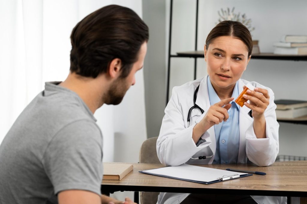 Same day STD test Houston: Physician holding medication bottle while consulting patient at desk, discussing treatment options after fast STD testing in Houston.