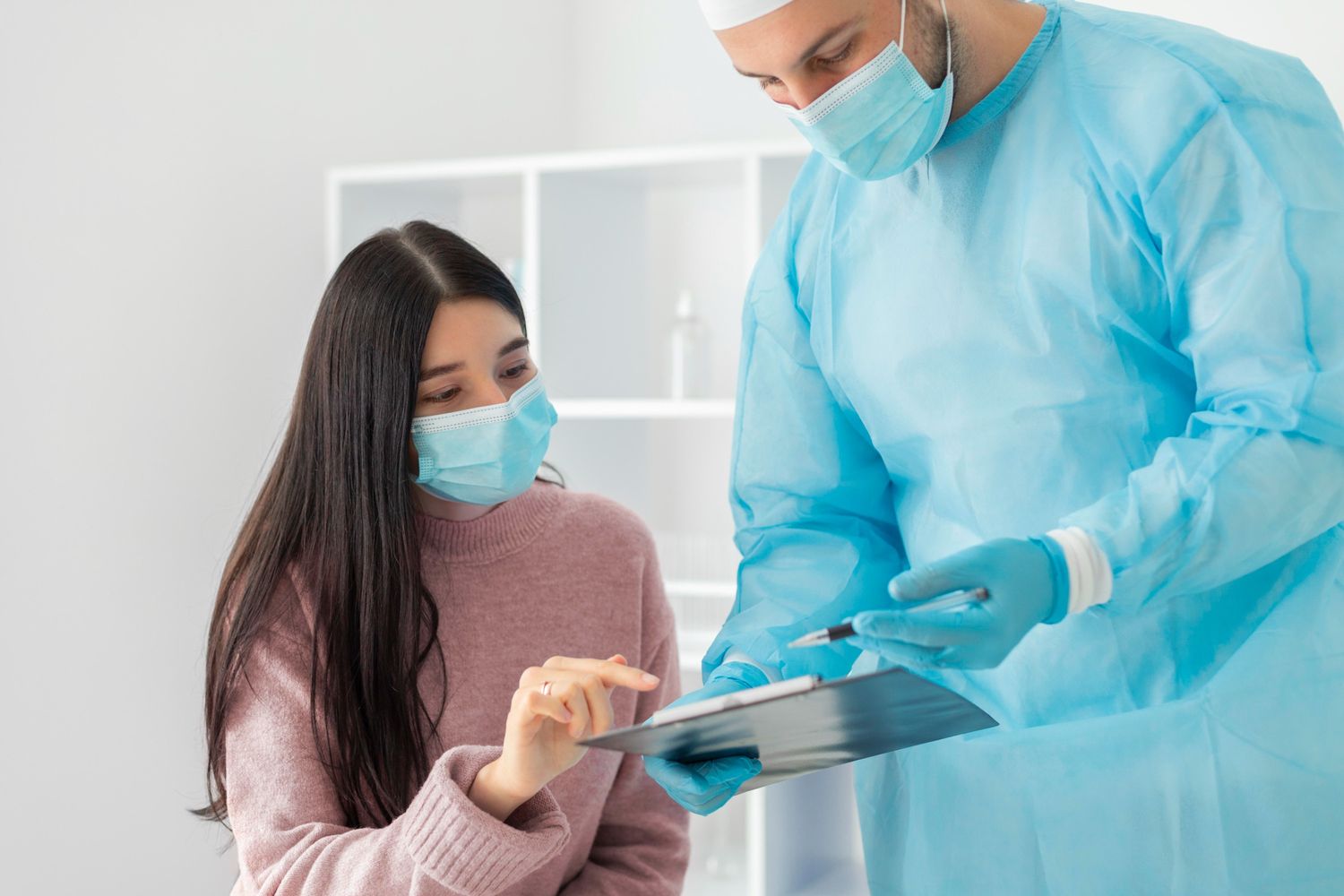 Same day STD test Houston: Doctor in protective gear reviewing clipboard with masked patient in a clean clinic setting, ensuring rapid and confidential testing.