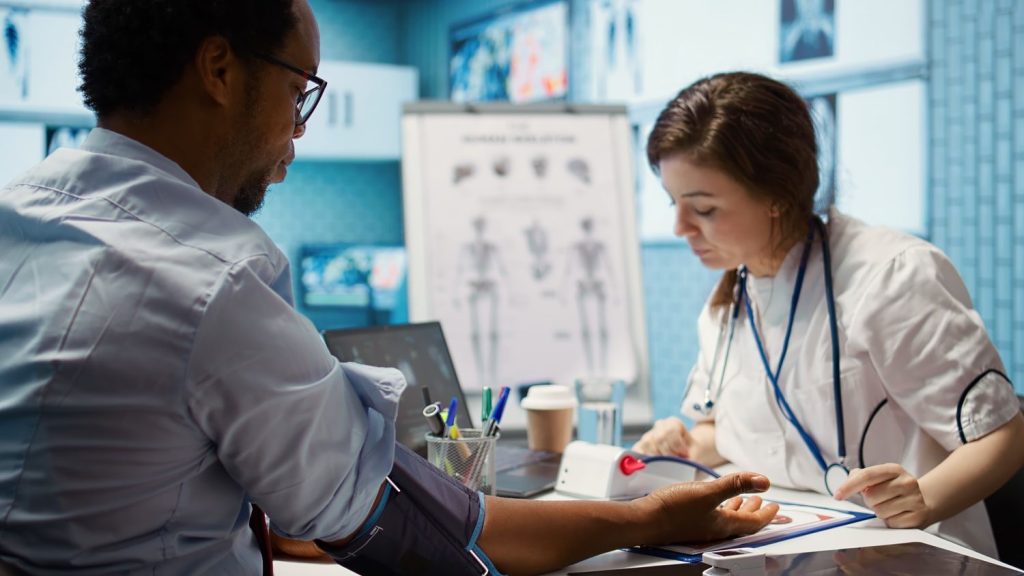 Same day STI test Houston: Doctor checking patient’s blood pressure in a modern clinic, offering quick STI testing services with expertise.