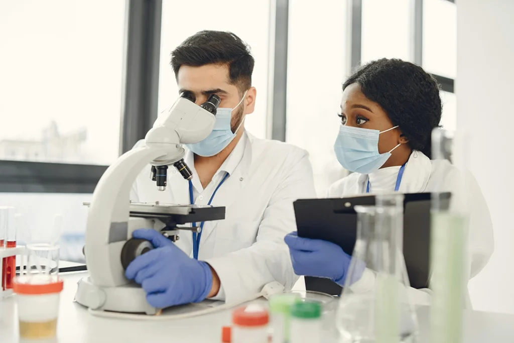 Lab workers analyzing samples under a microscope for affordable STD testing Houston results.