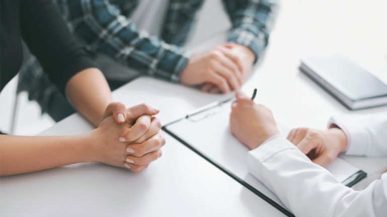 Doctor consults patients, documenting care during clinic visit; discreet same-day screening with cheap std testing houston.