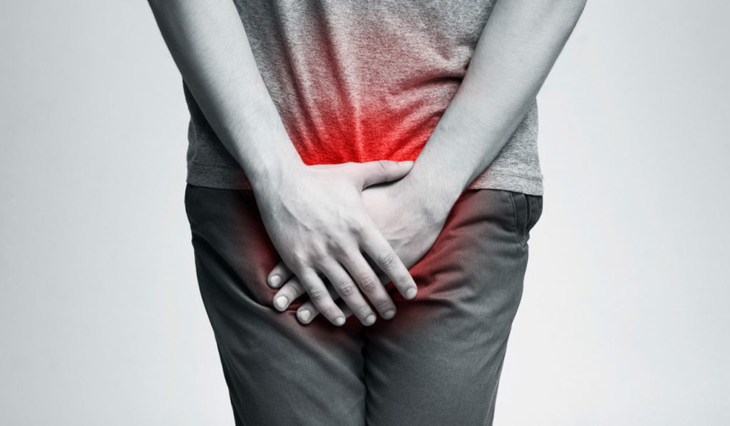 Man holding painful groin area symbolizing symptoms checked at an affordable STD testing Houston clinic for fast, discreet treatment