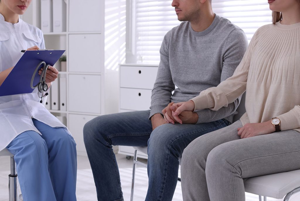 A young couple discusses walk in std testing houston options during a private consultation at a medical clinic.