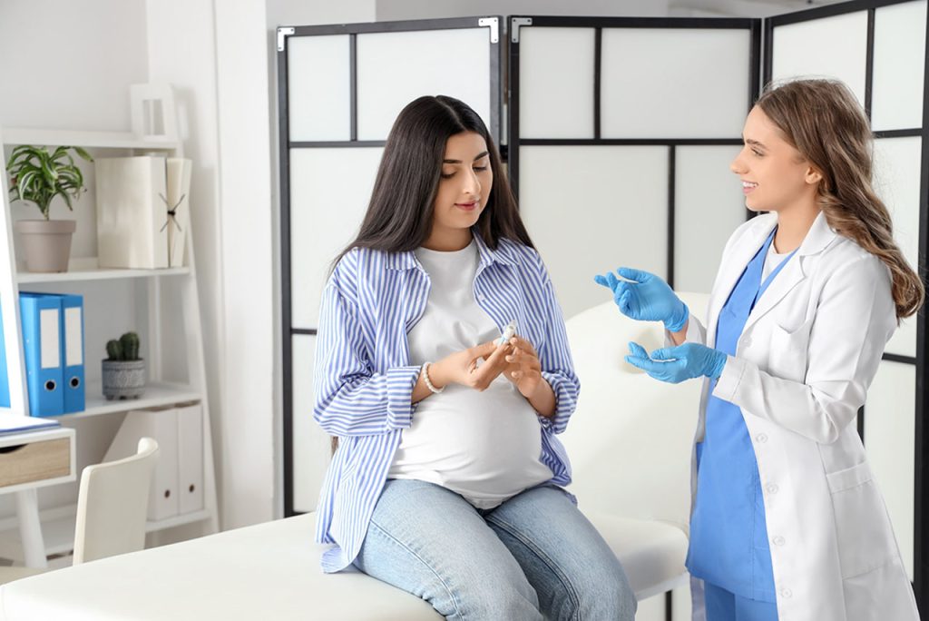 Pregnant woman consulting with a doctor in a clinic, essential for maternal health and STD treatment Houston.