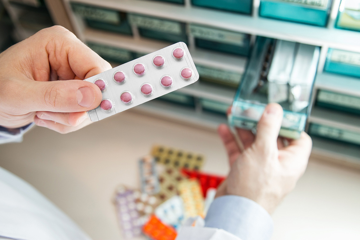 Pharmacist dispensing prescribed STD medication Houston patients need for treatment at a local professional pharmacy.
