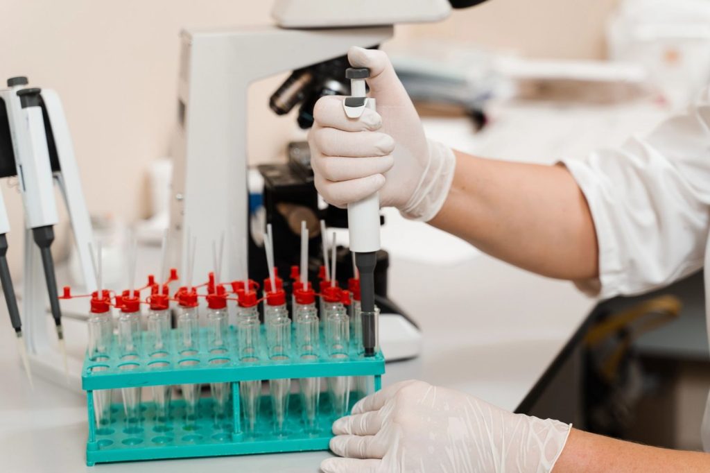 Medical technician using a pipette for cheap STD testing Houston lab services and affordable screening results.
