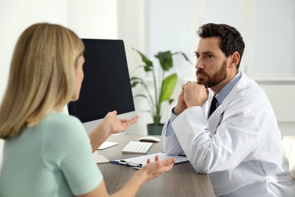 Male doctor providing walk in std testing Houston services during a confidential consultation with a female patient.
