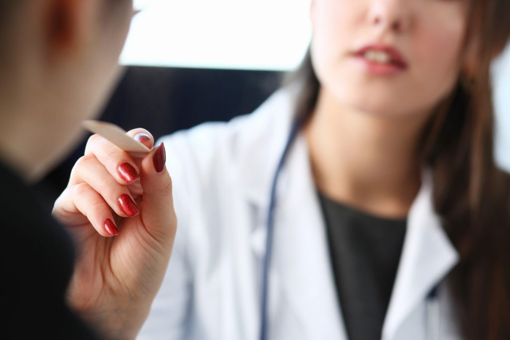 Medical professional performing a throat swab during a confidential STD testing Houston screening for a patient.