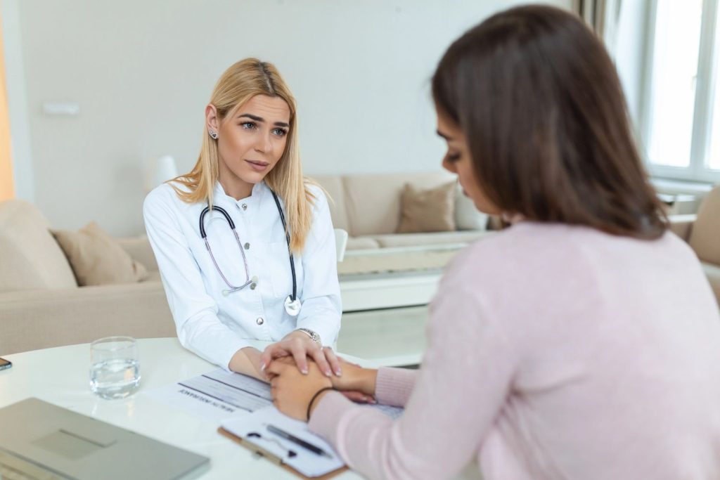 A female doctor providing empathetic counseling and health advice to a young woman visiting an urban sti clinic.