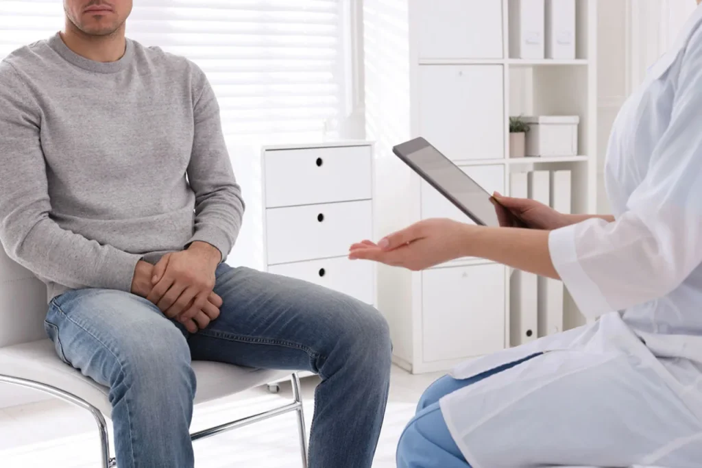 A modern medical provider reviews data on a tablet with a male patient. A private talk on confidential std testing Houston.